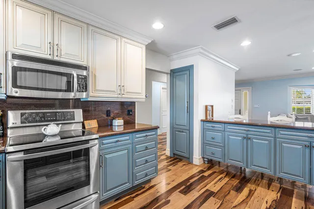 a kitchen with stainless steel appliances granite countertop a stove microwave and cabinets