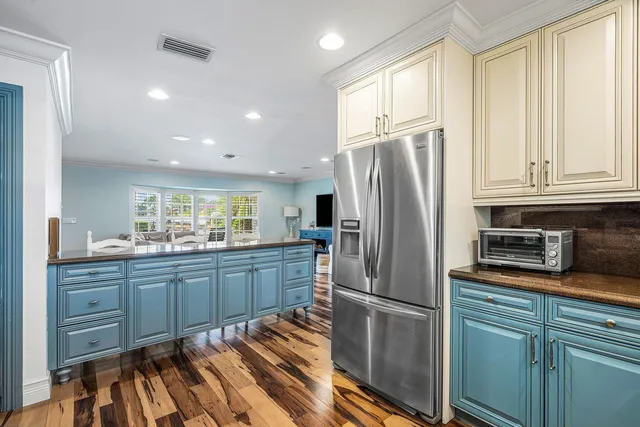 a kitchen with stainless steel appliances granite countertop a refrigerator and wooden cabinets