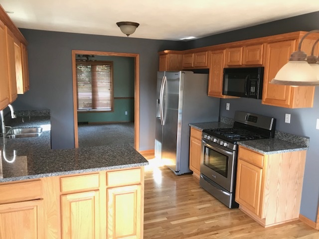 10675 Chicory Ridge Way Roscoe, IL 61073 - Photo 8 of 25 a kitchen with stainless steel appliances granite countertop a stove a sink and a microwave