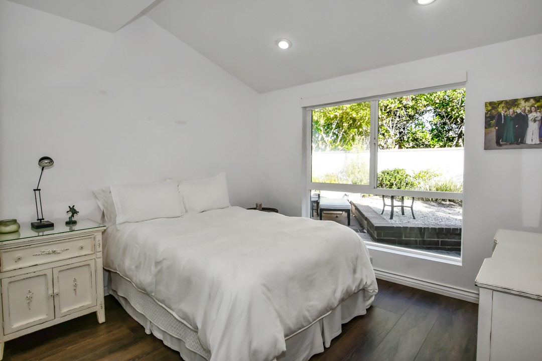 26 Shoal Drive Corona del Mar, CA 92625 - Photo 21 of 37 a bedroom with a large bed and a large window