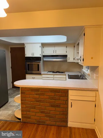 a kitchen with kitchen island a sink and a stove