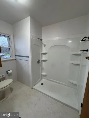 a bathroom with a granite countertop shower and a toilet