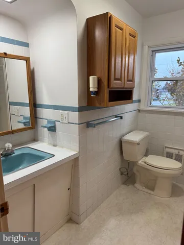 a bathroom with a sink a toilet and mirror