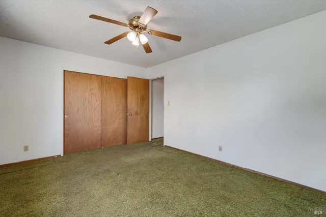 a view of a room with a ceiling fan and a ceiling fan
