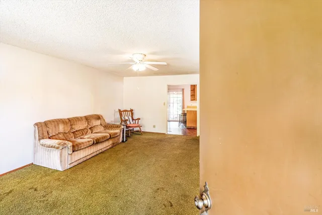 a living room with furniture and a ceiling fan