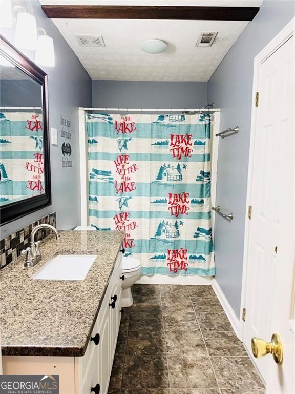 543 Saddle Ridge Drive Bethlehem, GA 30620 - Photo 26 of 36 a bathroom with a granite countertop sink and a mirror