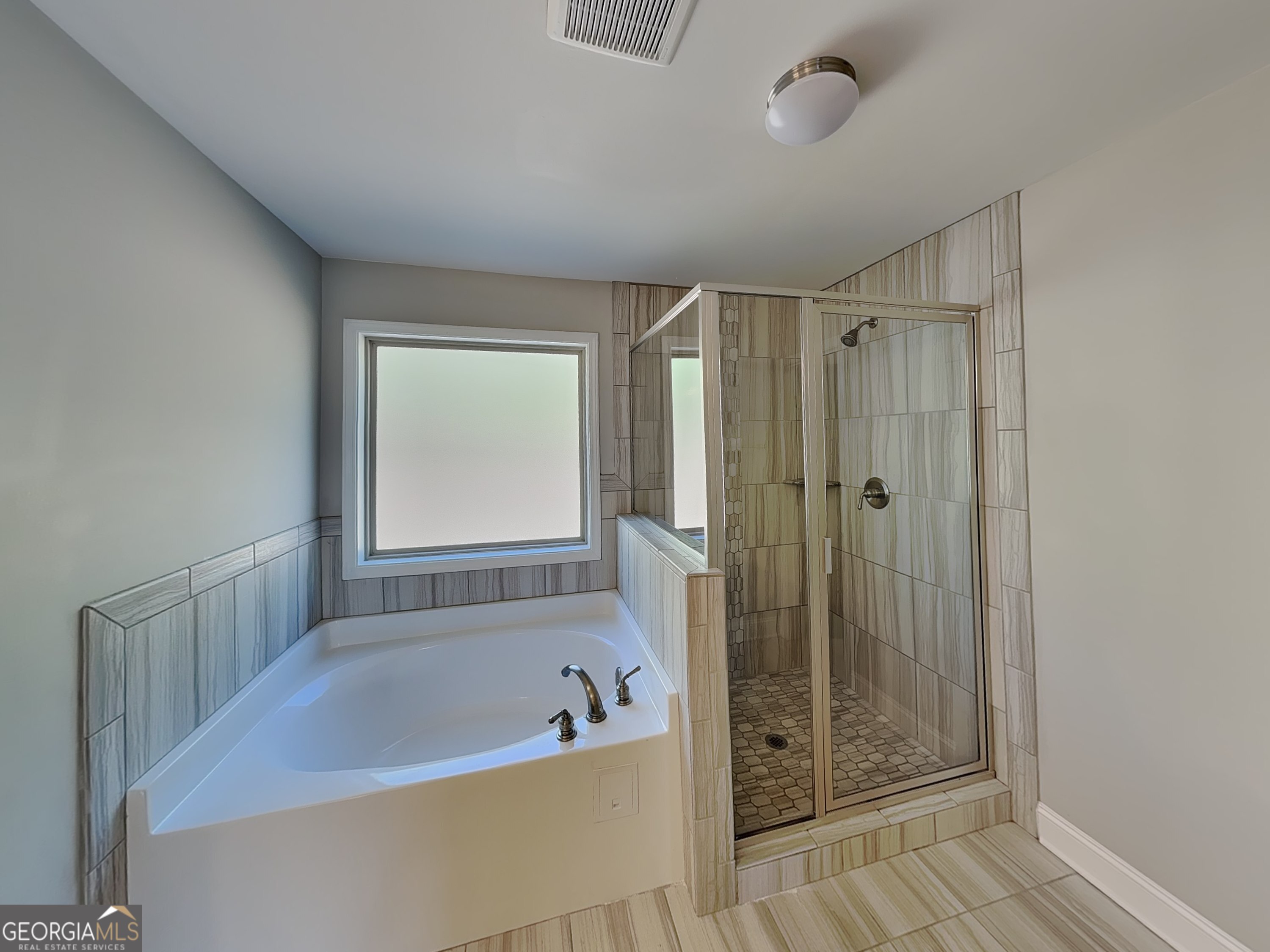1720 Cobblefield Circle Dacula, GA 30019 - Photo 11 of 23 a bathroom with a bathtub a shower and a window