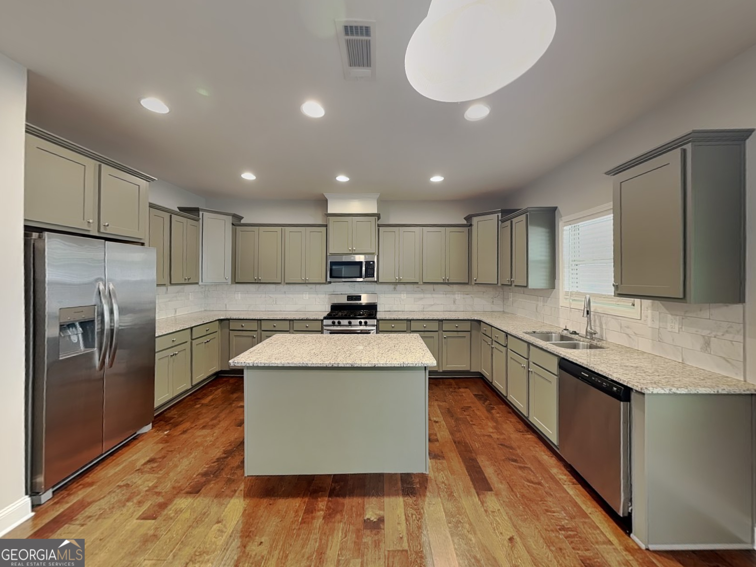 1720 Cobblefield Circle Dacula, GA 30019 - Photo 3 of 23 a large kitchen with stainless steel appliances kitchen island granite countertop a large counter top stainless steel appliances and cabinets