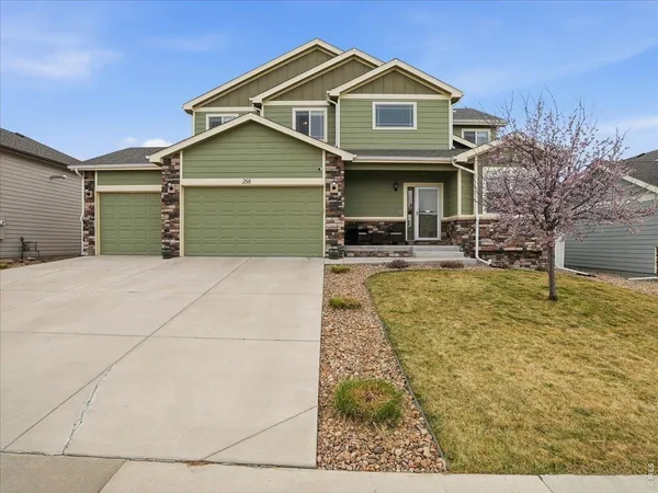 a front view of a house with yard and parking