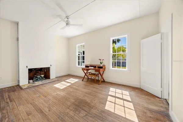 an empty room with windows and fireplace