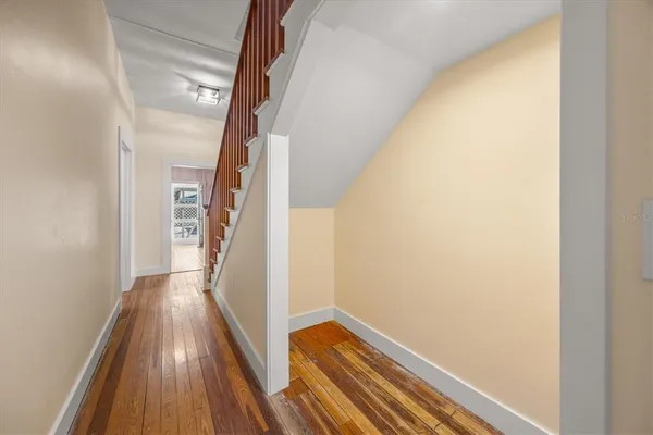 a view of a hallway with wooden floor and staircase