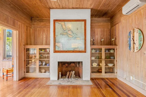 a view of a livingroom with wooden floor and a fireplace