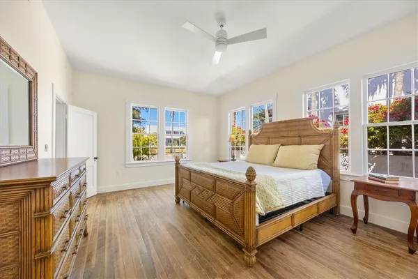 a bedroom with a bed and a large window with wooden floor