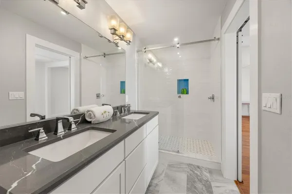 a bathroom with a sink double vanity granite and a mirror