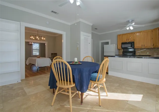 a view of kitchen with granite countertop dining table chairs cabinets and stainless steel appliances