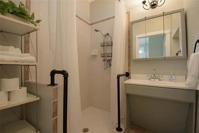 a bathroom with a sink a mirror a vanity and shower