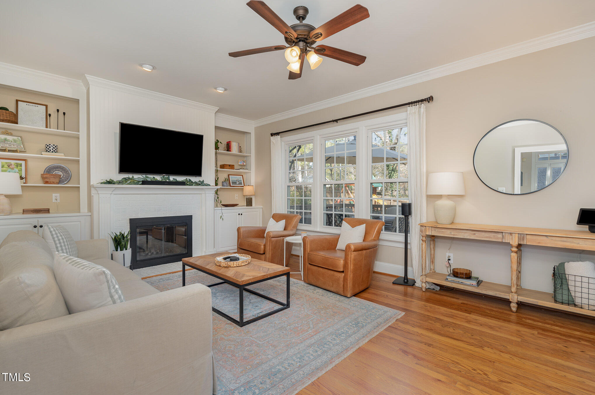 2500 Harptree Court Raleigh, NC 27613 - Photo 4 of 44 a living room with furniture a flat screen tv and a fireplace