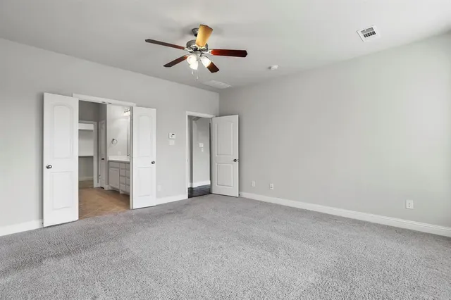 an empty room with closet and windows