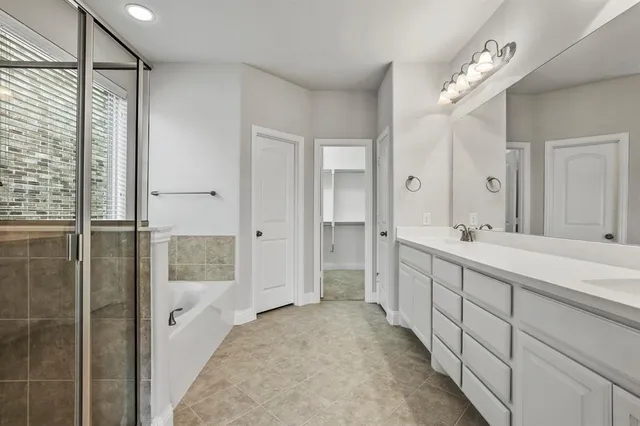 a spacious bathroom with a double vanity sink mirror and shower