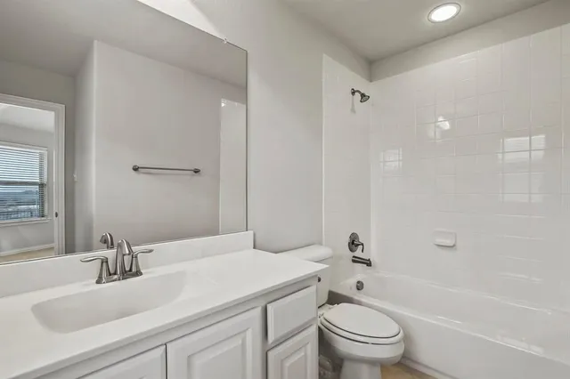 a bathroom with a granite countertop sink a toilet and a large mirror
