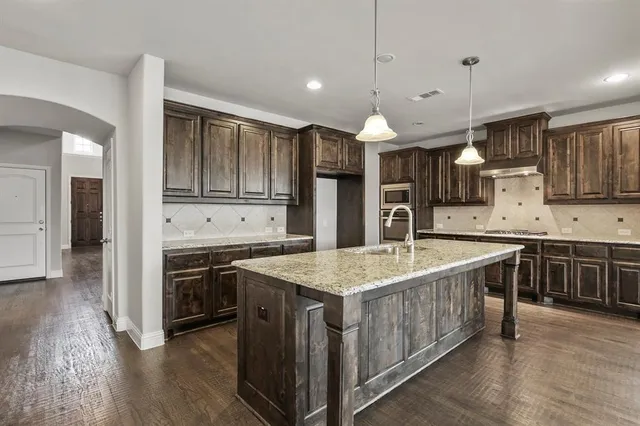 a kitchen with stainless steel appliances granite countertop a sink stove and cabinets