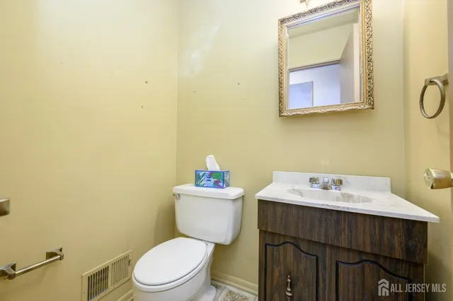 a bathroom with a toilet sink vanity and mirror