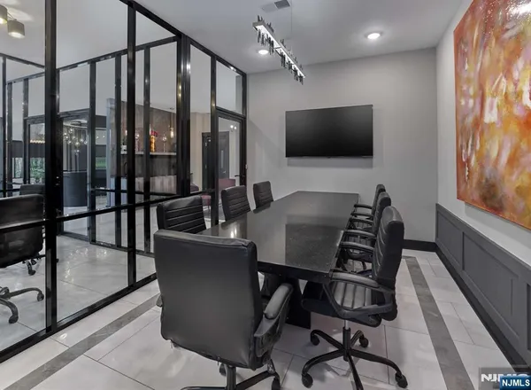 a living room with furniture a flat screen tv and floor to ceiling window