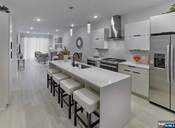 a kitchen with stainless steel appliances kitchen island a table chairs sink and cabinets