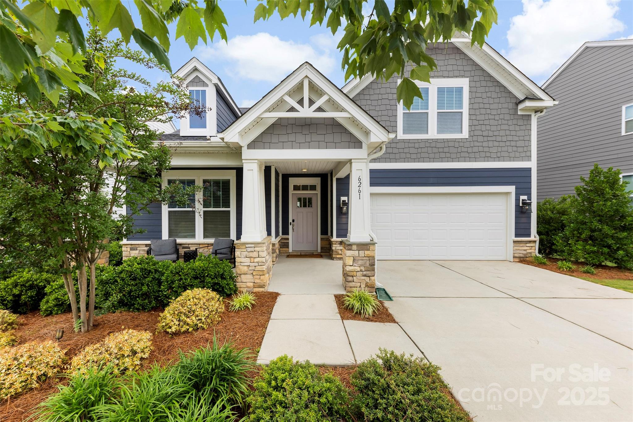 a front view of a house with a garden and plants