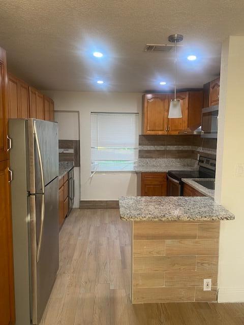 312 North 27th Street Fort Pierce, FL 34947 - Photo 5 of 10 a kitchen with granite countertop a refrigerator and a sink