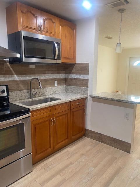 312 North 27th Street Fort Pierce, FL 34947 - Photo 9 of 10 a kitchen with stainless steel appliances granite countertop a sink microwave and stove
