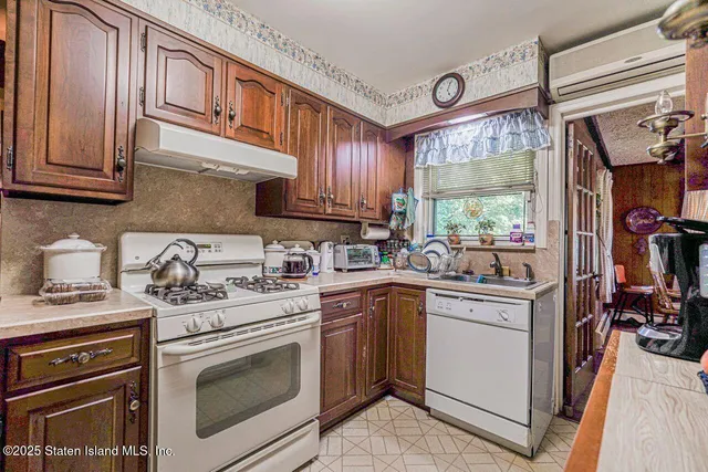 a kitchen with stainless steel appliances granite countertop a sink stove refrigerator and cabinets