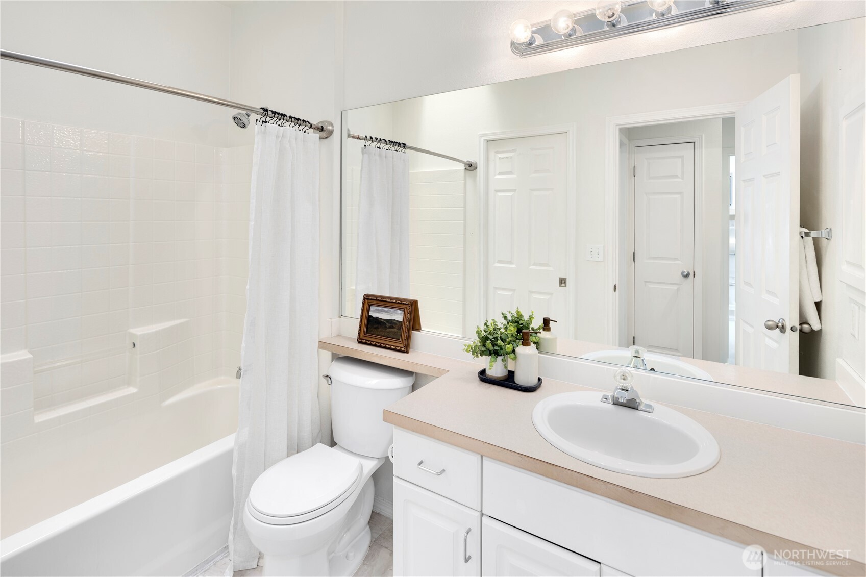 14120 Southeast 171st Way, Unit C303 Renton, WA 98058 - Photo 19 of 21 a bathroom with a sink toilet a mirror and shower