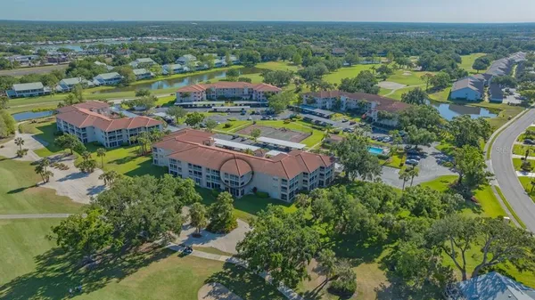 an aerial view of residential houses with outdoor space and trees