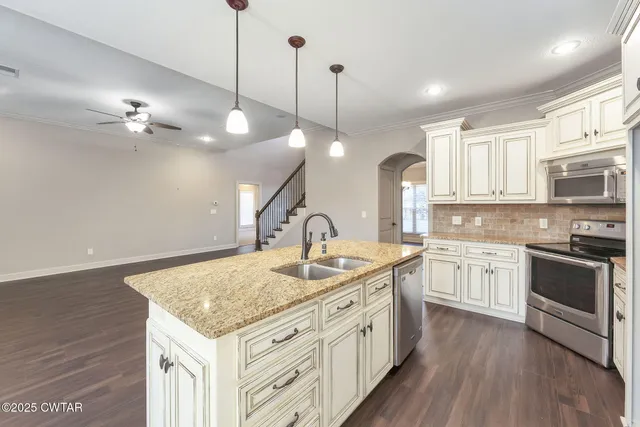a kitchen with stainless steel appliances granite countertop a sink stove and wooden floor