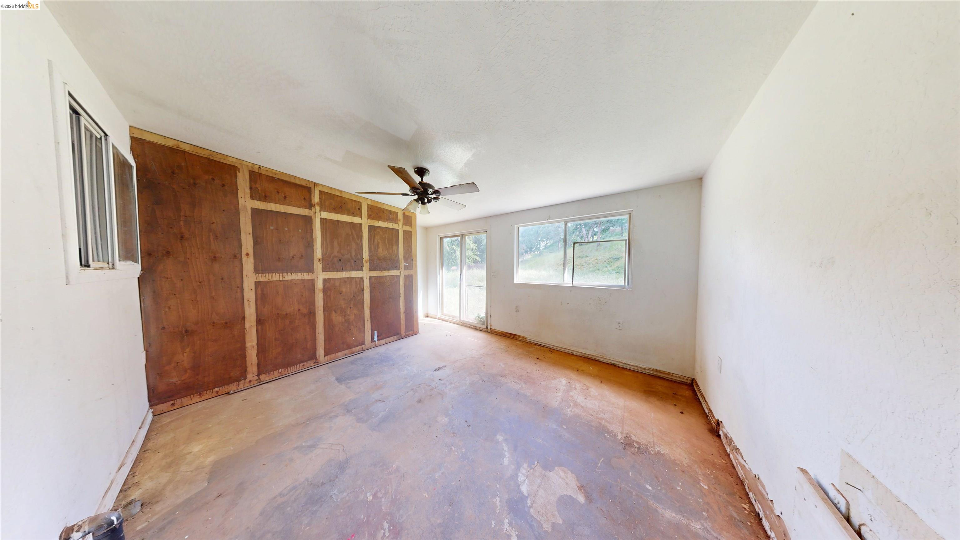 20231 Hidden Acres Road Sonora, CA 95370 - Photo 16 of 25 Spacious interior room featuring a ceiling fan, multiple windows, and a sliding glass door