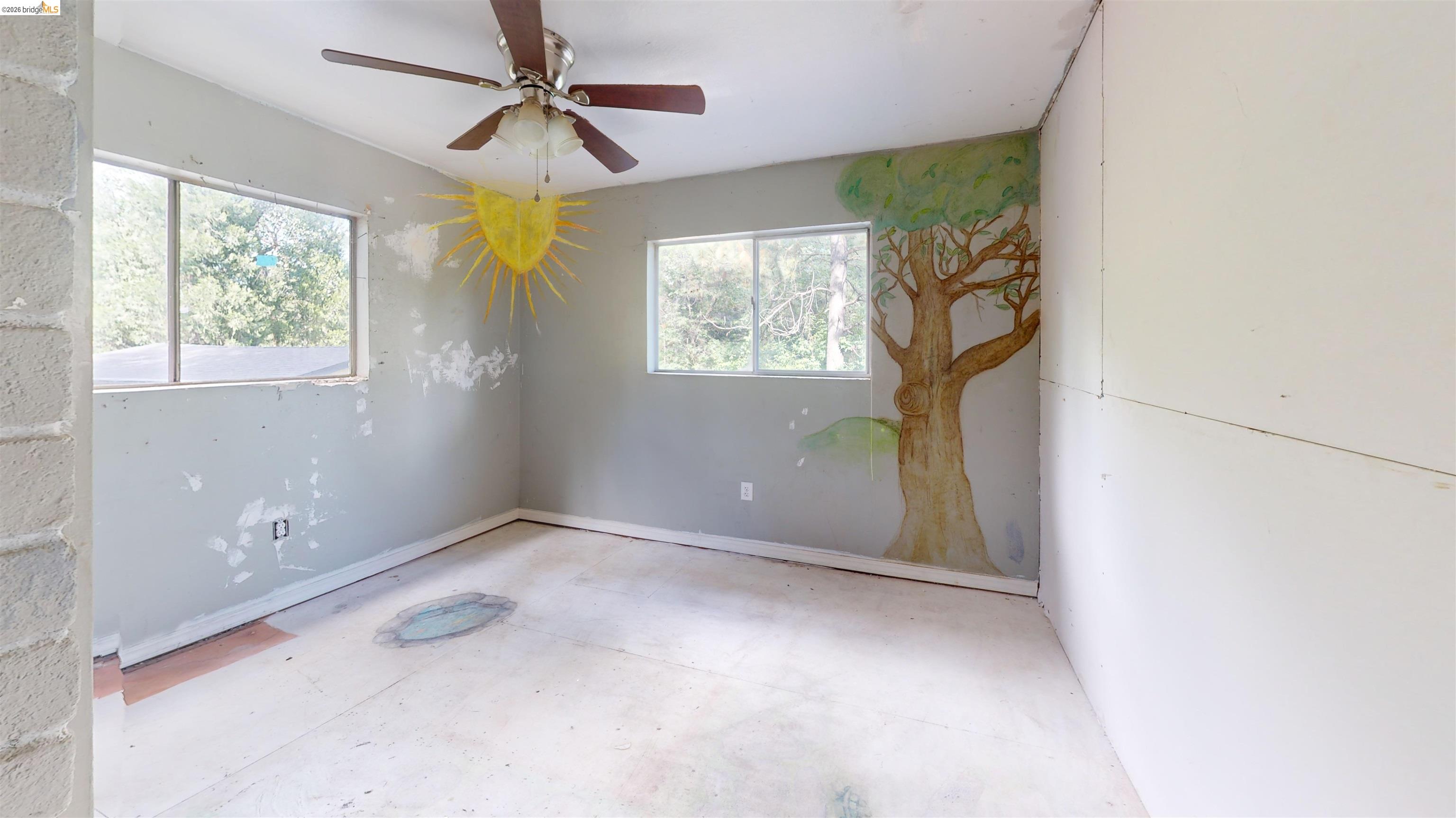 20231 Hidden Acres Road Sonora, CA 95370 - Photo 19 of 25 Room featuring two windows, a ceiling fan, and partially finished walls