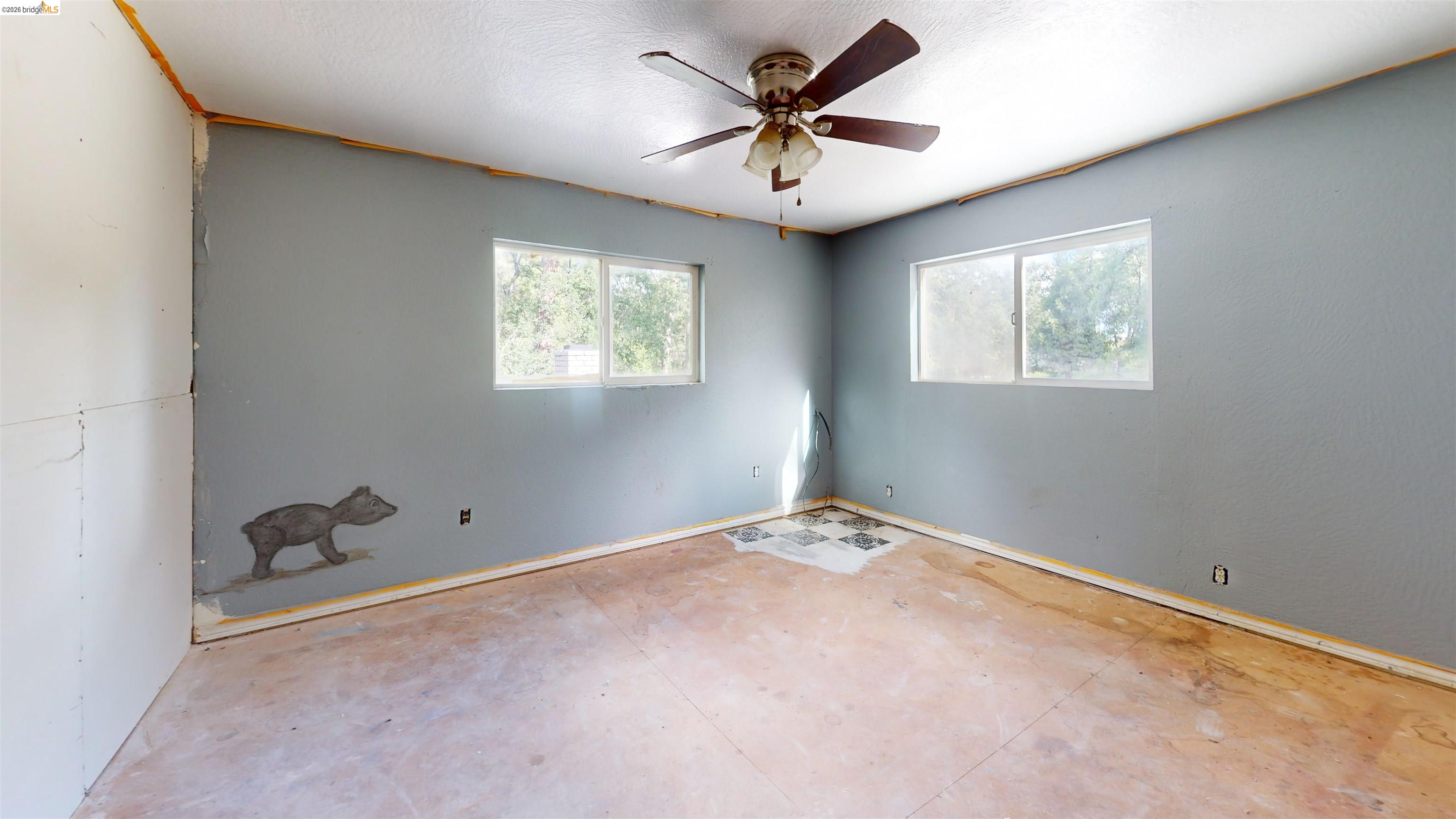 20231 Hidden Acres Road Sonora, CA 95370 - Photo 21 of 25 Room featuring two windows, a ceiling fan, and exposed subfloor