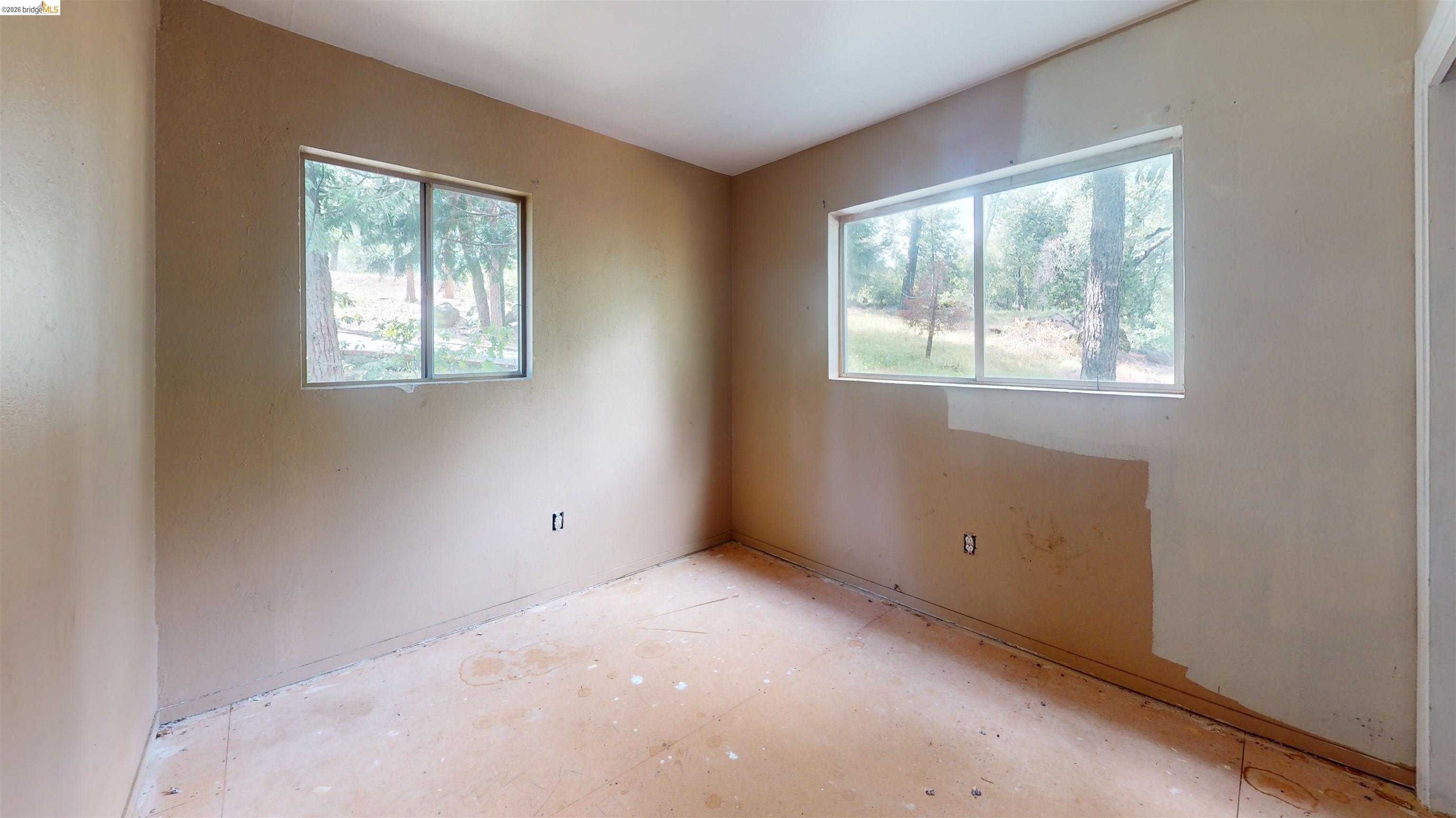 20231 Hidden Acres Road Sonora, CA 95370 - Photo 22 of 25 Room featuring natural light from two windows, untextured walls, and a concrete subfloor