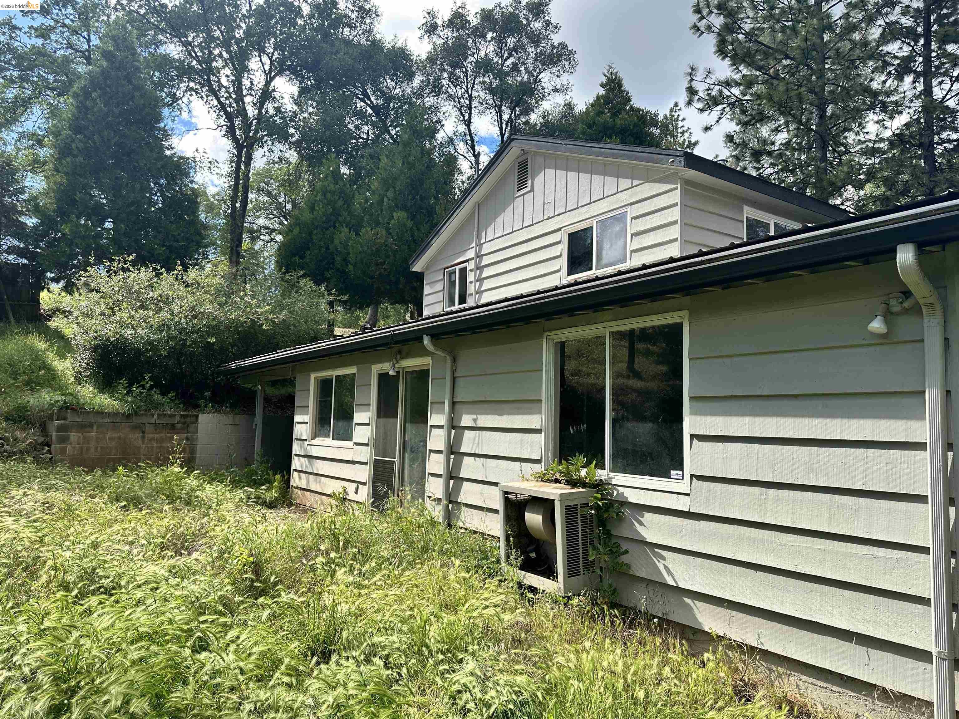 20231 Hidden Acres Road Sonora, CA 95370 - Photo 3 of 25 Multi-level residence featuring horizontal siding, multiple windows, and a black roofline