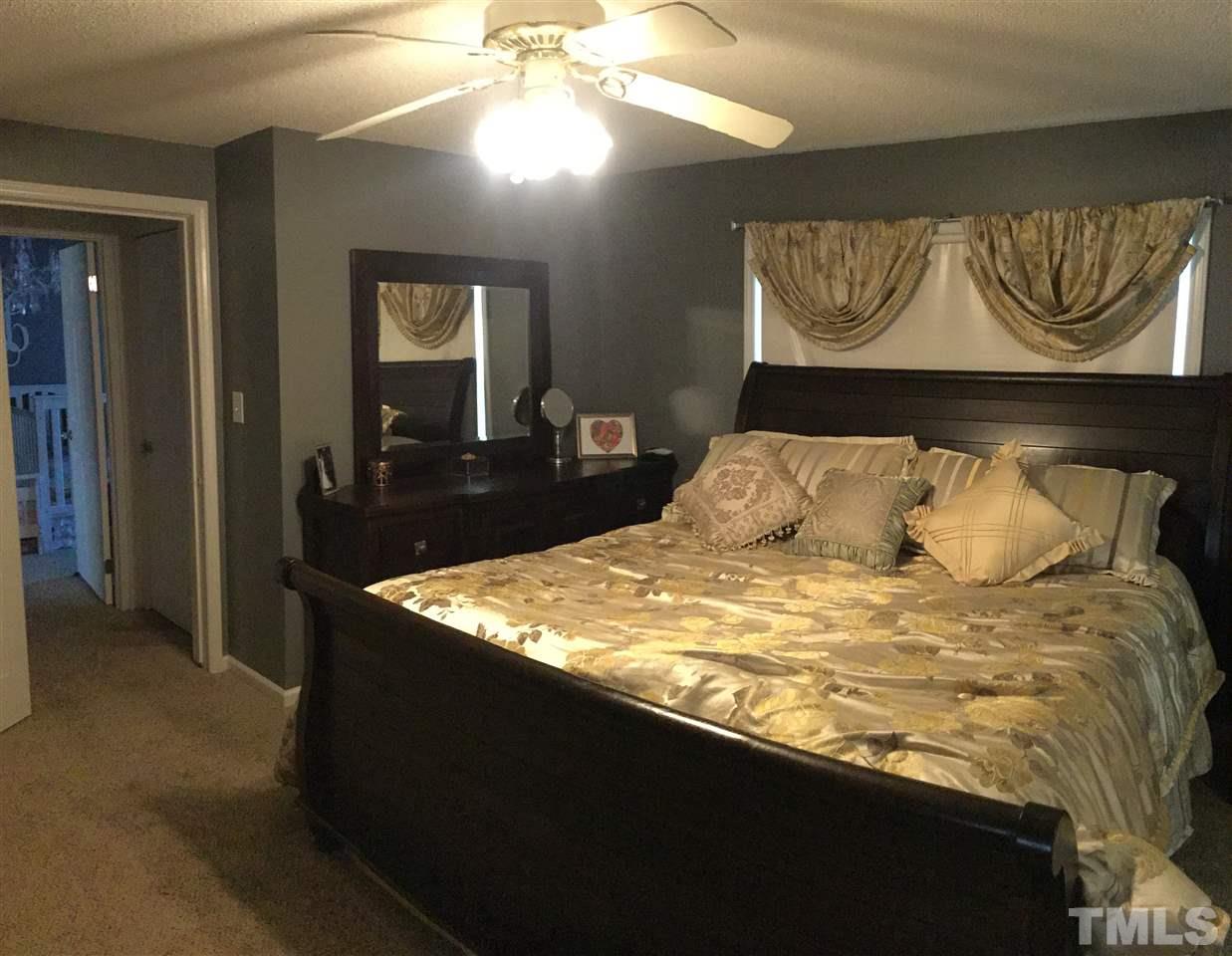 754 Drag Strip Road Benson, NC 27504 - Photo 10 of 16 a bedroom with a bed and a chandelier
