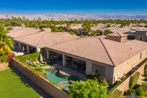 an aerial view of a house with swimming pool and a yard