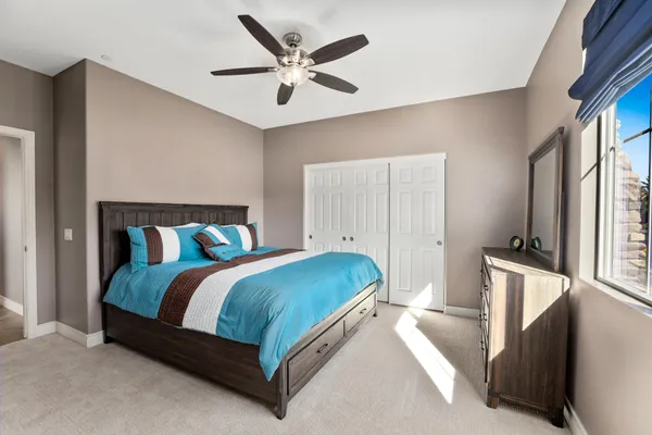 a bedroom with a bed and a large window