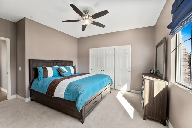 a bedroom with a bed and a large window