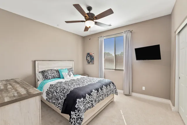 a bedroom with a large bed and a flat tv screen