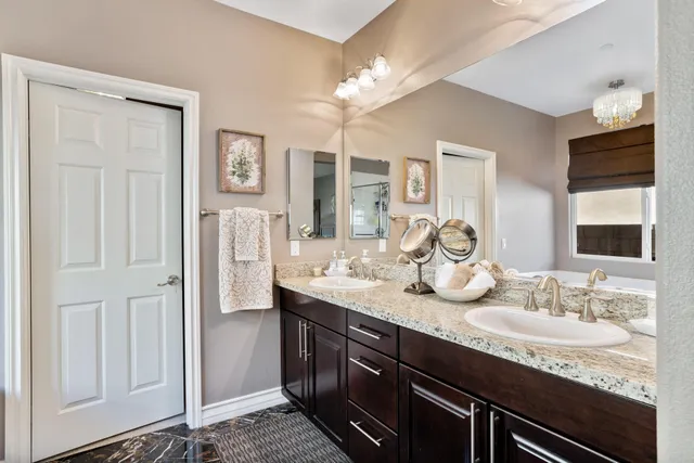 a bathroom with double vanity and a mirror