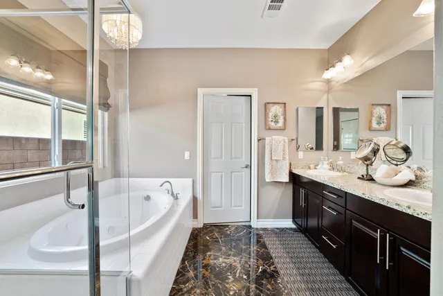 a spacious bathroom with a tub sink and mirror