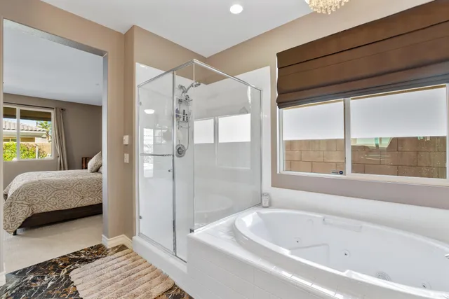 a bathroom with a tub shower and window
