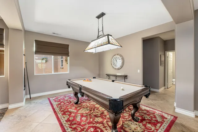 a room with pool table and windows