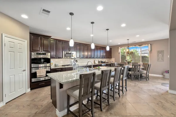 a kitchen with cabinets and chairs